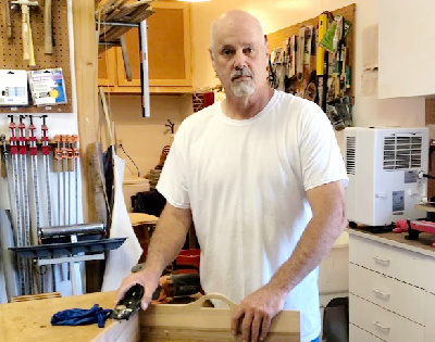 Tall man standing in his workshop