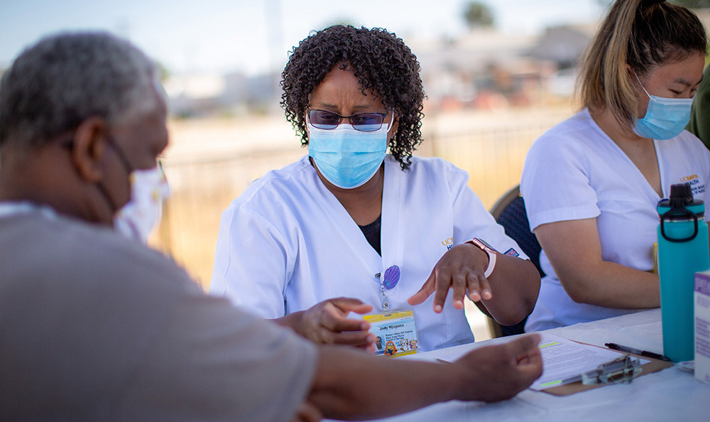 Nurse speaking to patient outside wearing masks