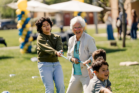 Alumni and students of all ages join forces for a spirited game of tug-of-war at this year's annual picnic.
