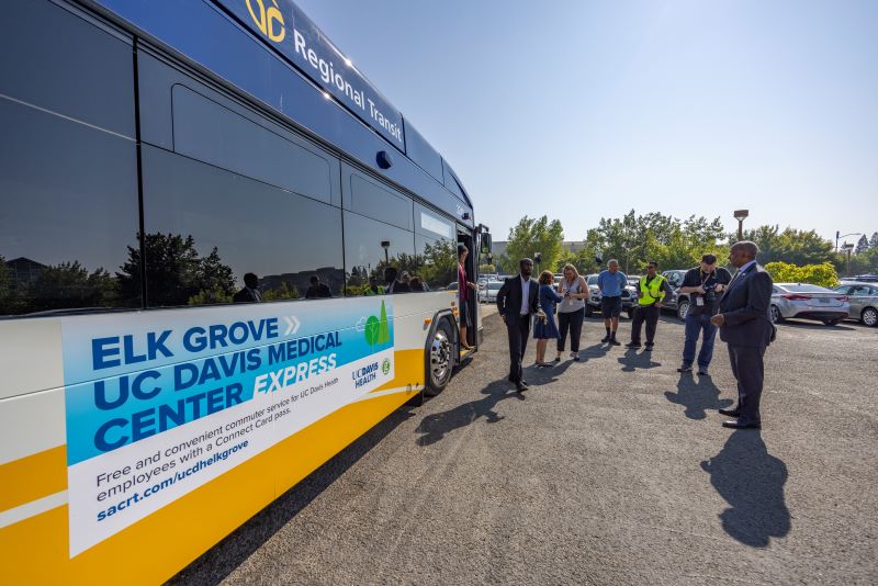 outside of bus with passengers standing nearby and exiting bus