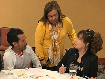 three people at table talking