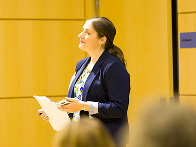 women standing and listening while holding papers