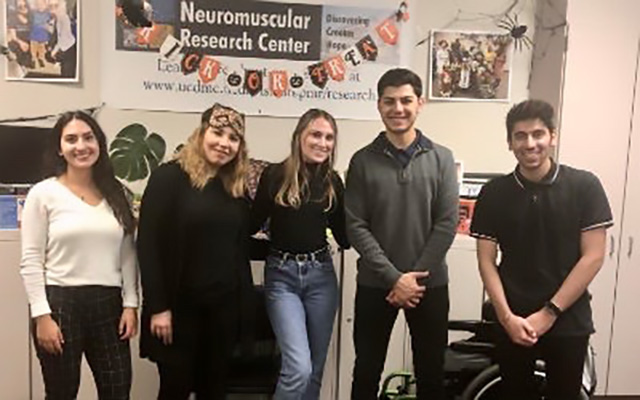 lab members smiling in front of trick-or-treat banner