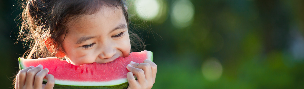 Girl eating slice of watermelon