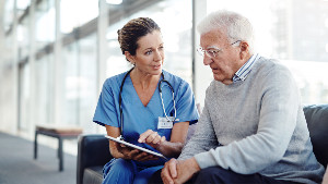 Nurse pointing at tablet sitting next to patient with delirium