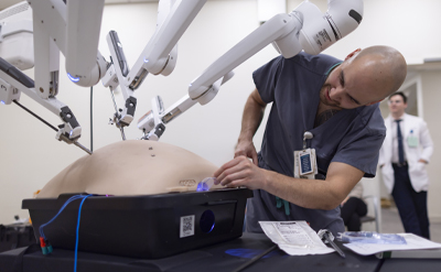 A clinician practices surgical procedures on a mannequin. (C) UC Davis Regents.
