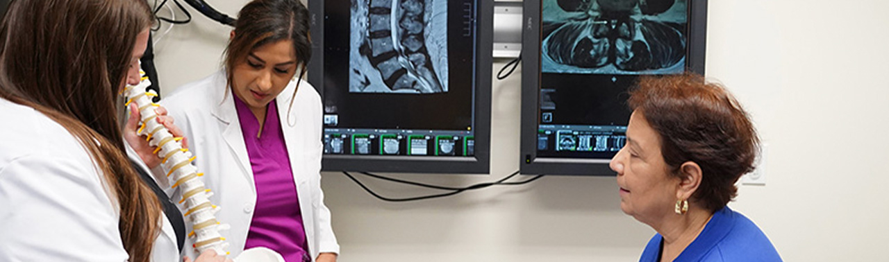 lady looking at spine structure model with advanced practice providers