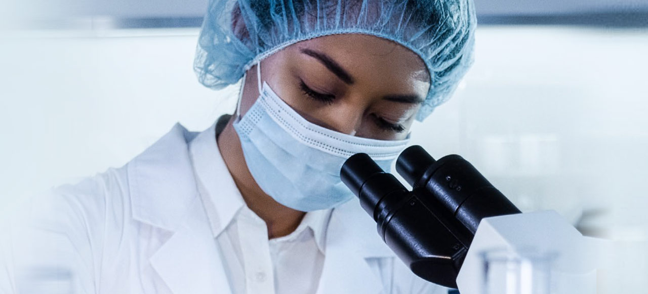 researcher looking into a microscope