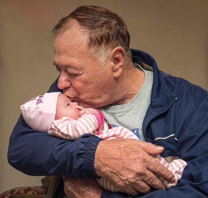 Buster Halcomb holding his newborn granddaughter