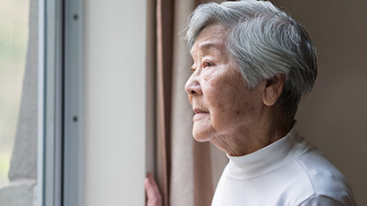 Asian American woman looking out the window